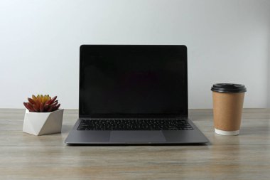 Modern ofisteki masada dizüstü bilgisayar ve kahve fincanı var. Metin için boşluk