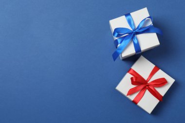 Parlak Noel süslemeleri ve mavi arka planda hediyeler