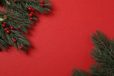 Hediye kutusu ıvır zıvırı üst görünümü, köknar dalı, kırmızı arkaplan, metin için boşluk