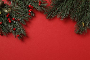 Hediye kutusu ıvır zıvırı üst görünümü, köknar dalı, kırmızı arkaplan, metin için boşluk