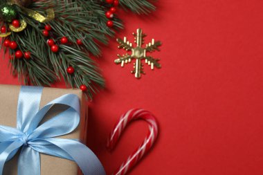 Hediye kutusu ıvır zıvırı üst görünümü, köknar dalı, kırmızı arkaplan, metin için boşluk