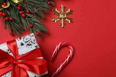 Hediye kutusu ıvır zıvırı üst görünümü, köknar dalı, kırmızı arkaplan, metin için boşluk