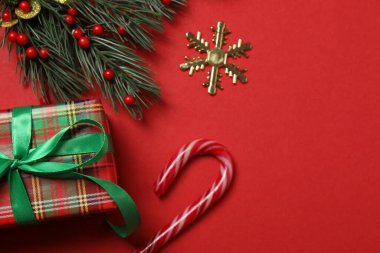 Hediye kutusu ıvır zıvırı üst görünümü, köknar dalı, kırmızı arkaplan, metin için boşluk