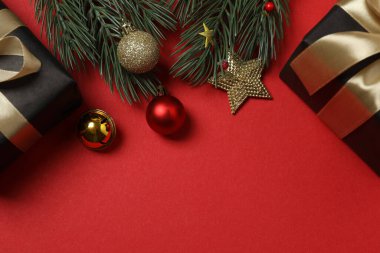 Hediye kutusu ıvır zıvırı üst görünümü, köknar dalı, kırmızı arkaplan, metin için boşluk