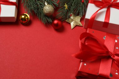 Hediye kutusu ıvır zıvırı üst görünümü, köknar dalı, kırmızı arkaplan, metin için boşluk