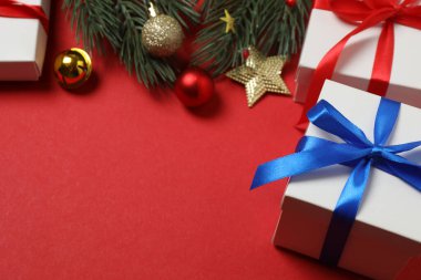 Hediye kutusu ıvır zıvırı üst görünümü, köknar dalı, kırmızı arkaplan, metin için boşluk