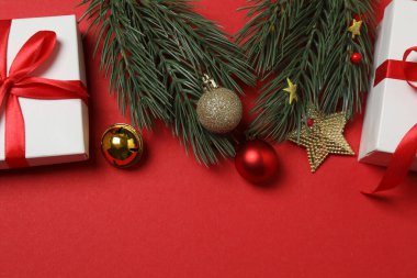 Hediye kutusu ıvır zıvırı üst görünümü, köknar dalı, kırmızı arkaplan, metin için boşluk