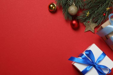 Hediye kutusu ıvır zıvırı üst görünümü, köknar dalı, kırmızı arkaplan, metin için boşluk