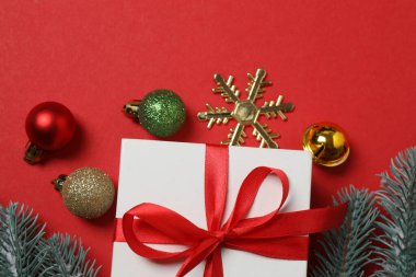 Hediye kutusu ıvır zıvırı üst görünümü, köknar dalı, kırmızı arkaplan, metin için boşluk