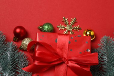 Hediye kutusu ıvır zıvırı üst görünümü, köknar dalı, kırmızı arkaplan, metin için boşluk