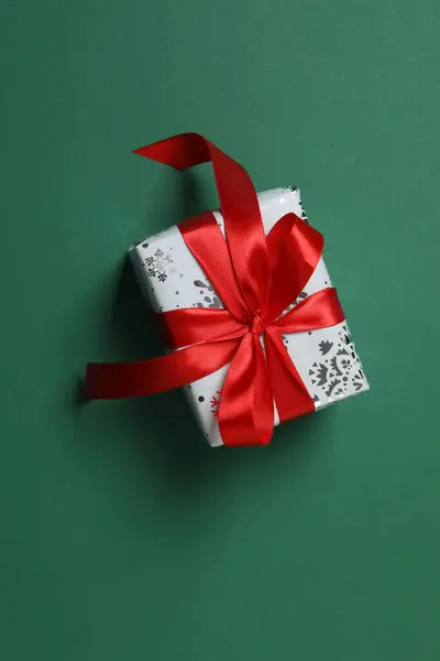 Yeşil bir arka planı olan hediye kutusu.