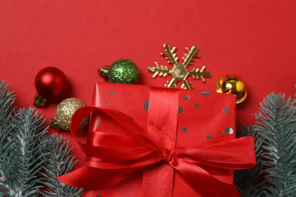 Hediye kutusu ıvır zıvırı üst görünümü, köknar dalı, kırmızı arkaplan, metin için boşluk