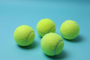 Tenis raketi, spor şişesi ve top mavi arka planda.