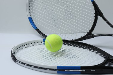 Beyaz arka planda tenis raketi ve top