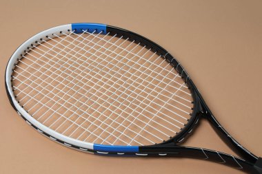 Tenis raketi, spor şişesi ve top bej arka planda