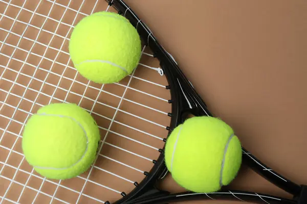 Tenis raketi, spor şişesi ve top bej arka planda