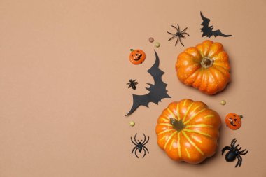 Portakal kabaklı Cadılar Bayramı, siyah yarasalar, bej arka planda sonbahar yaprakları