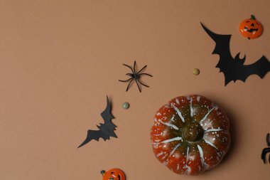 Portakal kabaklı Cadılar Bayramı, siyah yarasalar, bej arka planda sonbahar yaprakları