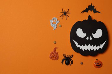 Portakal kabaklarıyla Cadılar Bayramı, siyah yarasalar, turuncu arka planda sonbahar yaprakları