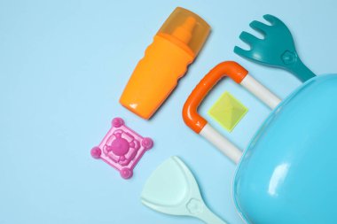 Çocuğun seyahat çantası, oyuncaklar, mavi arka planda baharatlı dondurma.