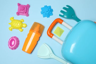 Çocuğun seyahat çantası, oyuncaklar, mavi arka planda baharatlı dondurma.