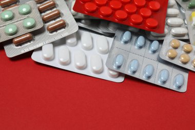 Kabarcıklar, haplar, kırmızı arka planda.