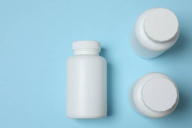 Mavi arka planda kavanozlar dolusu hap.