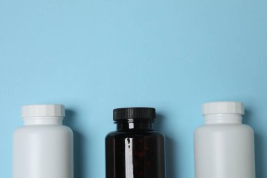 Mavi arka planda kavanozlar dolusu hap.