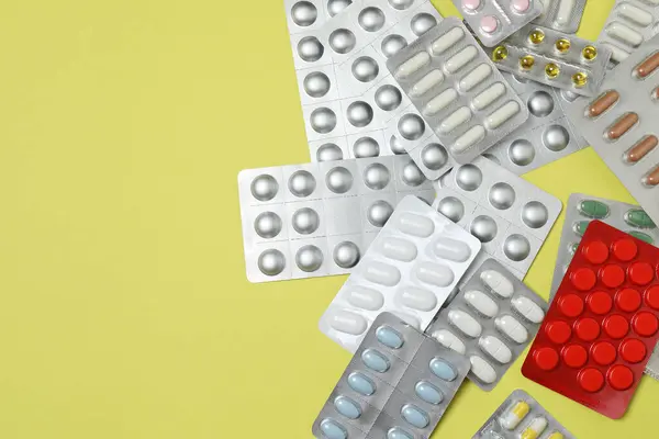 Kabarcıklar tabletlerle, tabletlerle, sarı arka planda