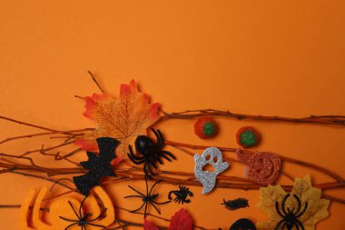 Kafatası, keneler, turuncu akçaağaç yaprakları, yarasalar, turuncu arkaplandaki örümcekler ile Cadılar Bayramı.