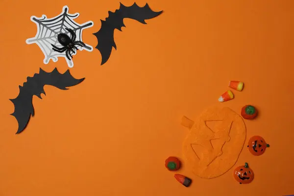 Kafatası, keneler, turuncu akçaağaç yaprakları, yarasalar, turuncu arkaplandaki örümcekler ile Cadılar Bayramı.