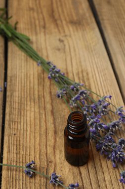 Lavanta yağlı şişeler, ahşap arka planda lavanta.