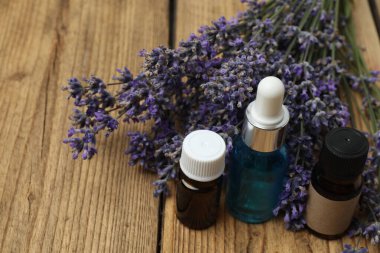 Lavanta yağlı şişeler, ahşap arka planda lavanta.