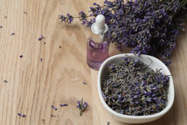 Lavanta yağlı şişeler, ahşap arka planda lavanta.