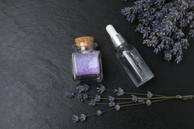 Lavanta ve lavanta yağı siyah mermer üzerinde şişelerde