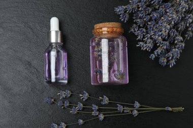 Lavanta ve lavanta yağı siyah mermer üzerinde şişelerde