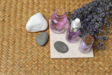 Hasır üzerinde şişe içinde lavanta ve lavanta yağı