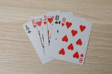 Dört as ve ahşap masa üzerinde poker fişleri