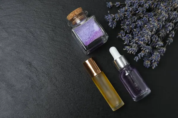 Lavanta ve lavanta yağı siyah mermer üzerinde şişelerde
