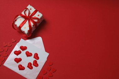 Kırmızı arkaplanda metin için yeri olan hediye kutusu ve zarf