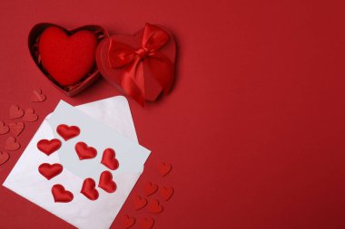 Kırmızı arkaplanda metin için yeri olan hediye kutusu ve zarf