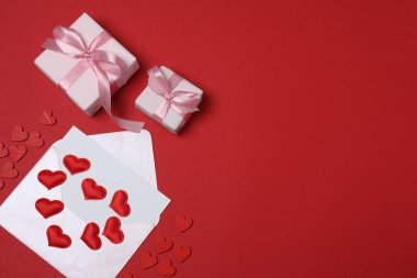 Kırmızı arkaplanda metin için yeri olan hediye kutusu ve zarf