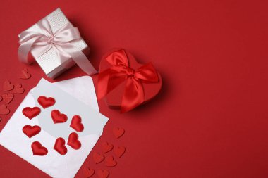 Kırmızı arkaplanda metin için yeri olan hediye kutusu ve zarf