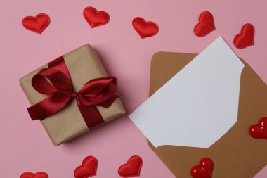 Pembe arkaplanda metin için yeri olan hediye kutusu ve zarf