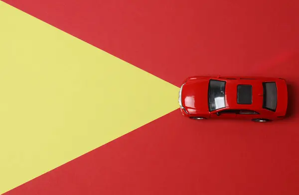Kırmızı arka planda oyuncak araba