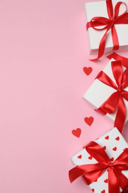 hediye kutuları, pembe arkaplandaki kalpler ve metin için boşluk