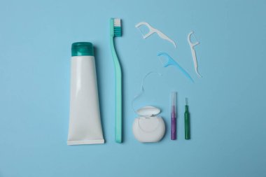 Diş fırçası, diş macunu, diş ipi, mavi arka planda diş fırçası.