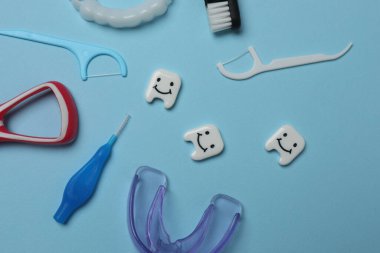 Diş fırçası, diş macunu, diş ipi, mavi arka planda diş fırçası.