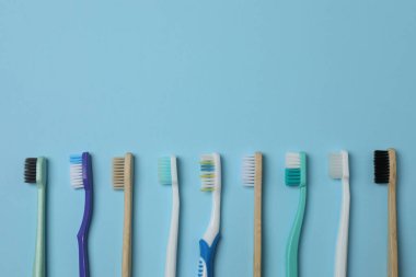 Diş fırçası, diş macunu, diş ipi, mavi arka planda diş fırçası.