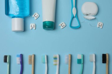 Diş fırçası, diş macunu, diş ipi, mavi arka planda diş fırçası.